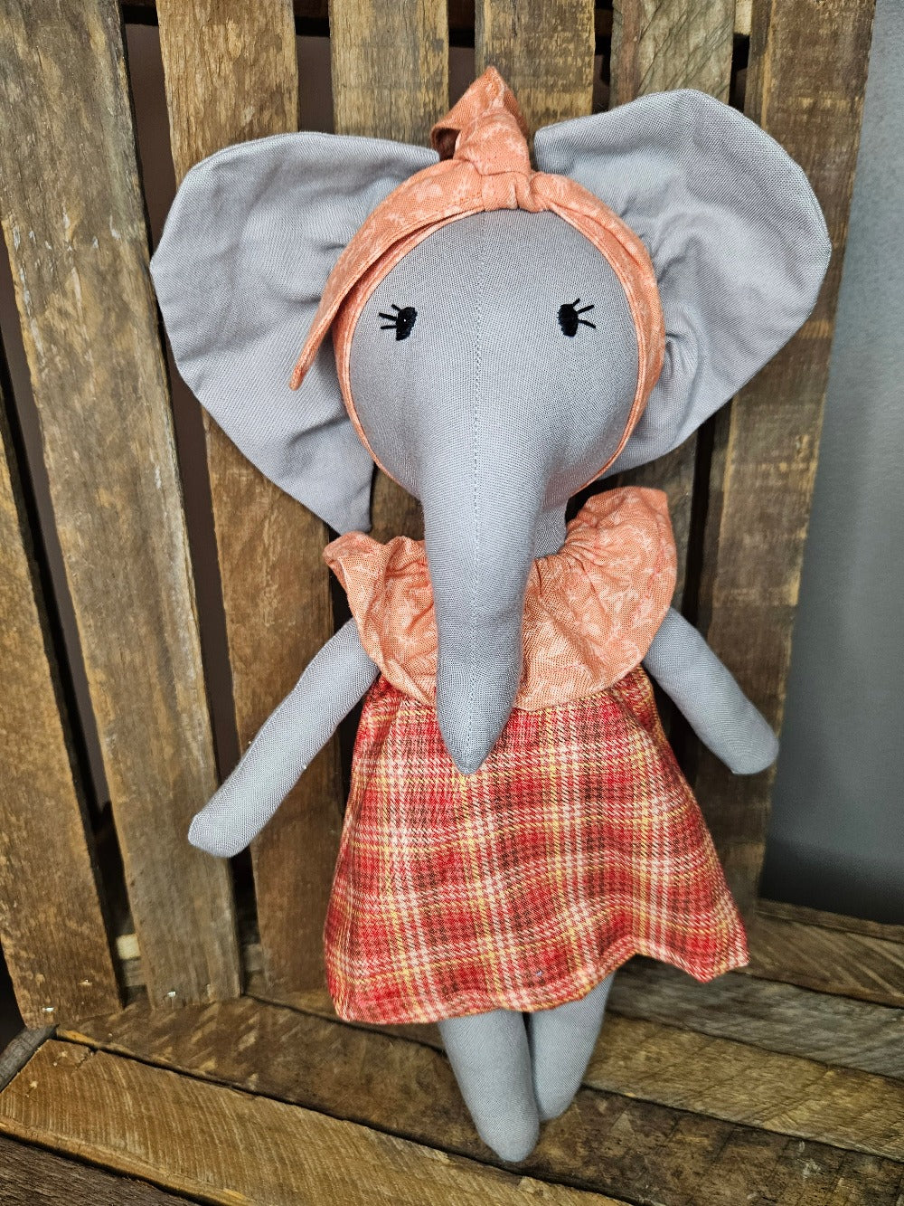 Light gray elephant with an orange plaid dress and light orange collar