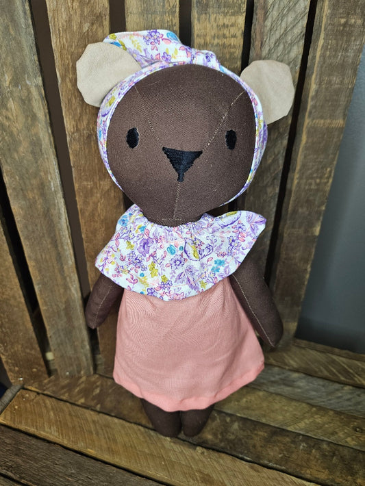 Dark brown bear in peach dress with floral collar