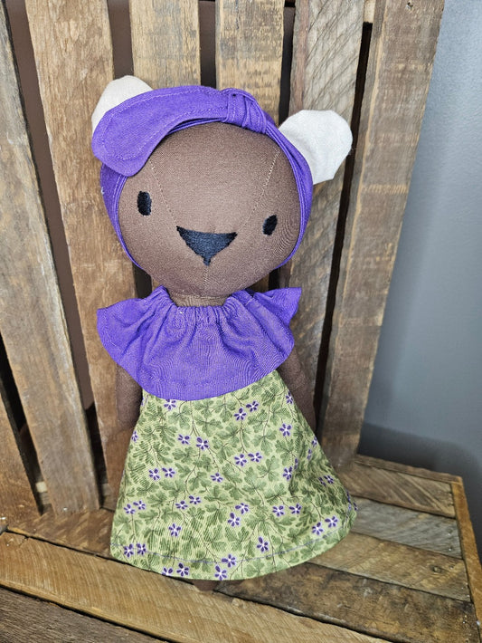 Brown bear with green and purple floral dress with purple collar