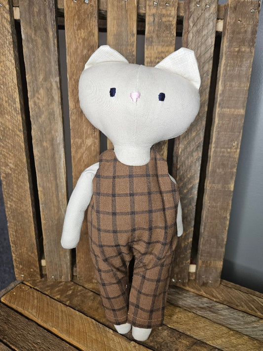 Light Tan kitten in brown and black plaid overalls
