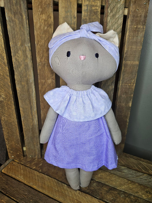 Light brown kitten in lavender dress